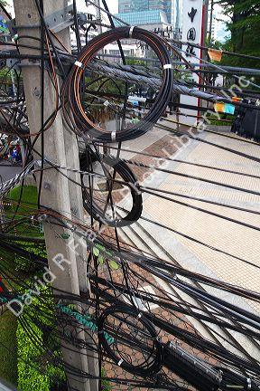 Utility pole with assorted cables and wires in Bangkok, Thailand.