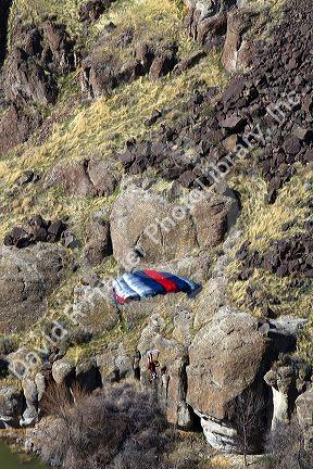 A BASE jumper parachuting from the I.B. Perrine Bridge spanning the Snake River canyon at Twin Falls, Idaho, USA.