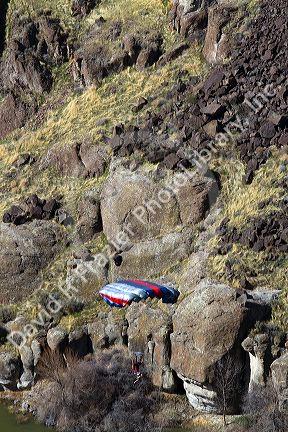 A BASE jumper parachuting from the I.B. Perrine Bridge spanning the Snake River canyon at Twin Falls, Idaho, USA.