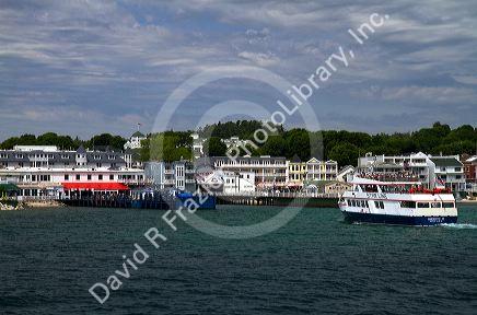 Lakefront historic buildings and ferry boat on Mackinac Island located in Lake Huron, Michigan, USA.