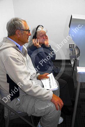 Visually impared woman using a headset for voting assistance at a polling station in Boise, Idaho, USA.