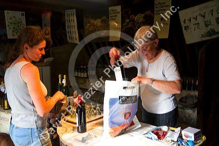 French woman purchasing wine at a winery in rural Angouleme in southwestern France.