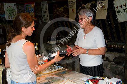 French woman purchasing wine at a winery in rural Angouleme in southwestern France.