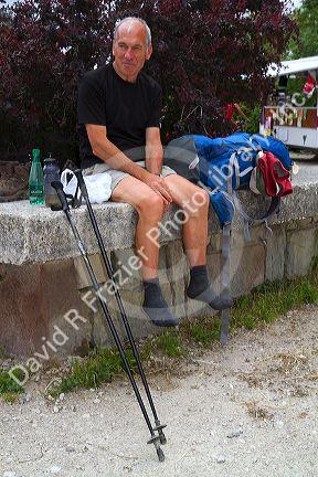Modern day pilgrim resting along the Camino De Santiago, the Way of St. James pilgrimage route in the Pyrenees mountains at the border of France and Spain.