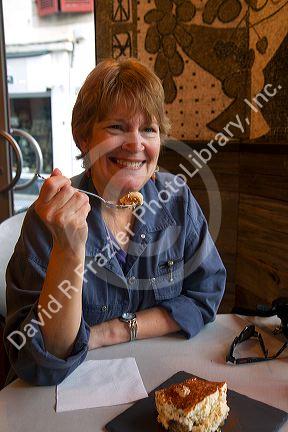 American tourist eating a dessert of tiramisu in a restaurant at Bidart in the Basque province of Labourd, southwestern France.