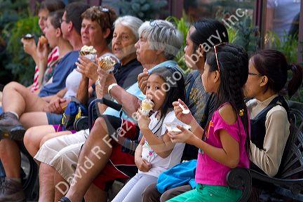 Tourists eat ice cream at Waterton Park townsite in Waterton Lakes National Park, Alberta, Canada.