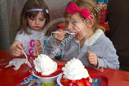 Sisters eating strawberry shortcake at Parksdale Farm in Plant City, Florida, USA. MR