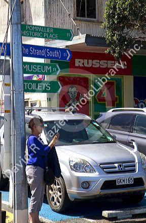 Woman taking a photo with an ipad in the waterfront town of Russell on the Bay of Islands, North Island, New Zealand.