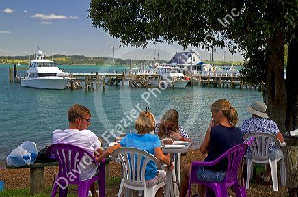 People eating outdoors in the waterfront town of Russell on the Bay of Islands, North Island, New Zealand.