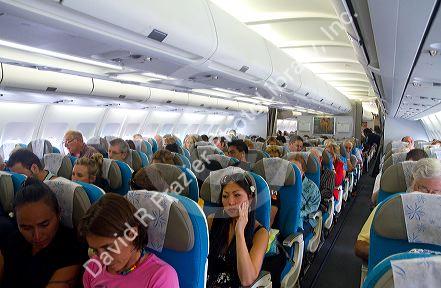 Passengers aboard an Airbus 340 seated in the economy cabin.