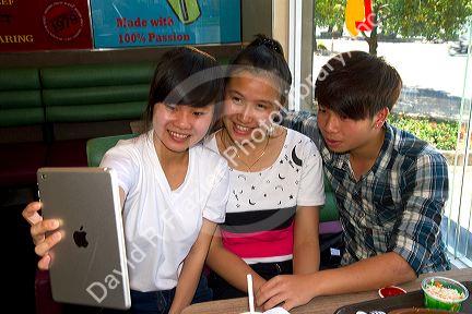 Vietnamese teenagers taking selfies with an ipad in Da Lat, Vietnam.