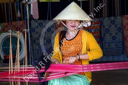 Vietnamese woman weaving silk into cloth near Da Lat, Vietnam.