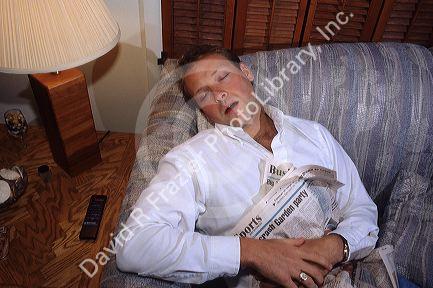 A adult male sleeping on the couch.