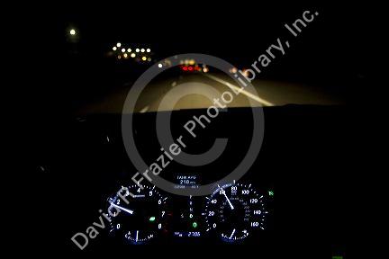 Driver's eye view of dashboard and highway at night in Ada County, Idaho, USA.