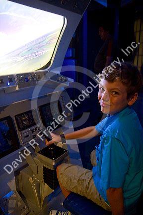Boy using a flight simulator at the John F. Kennedy Space Center, Merritt Island, Florida, USA.