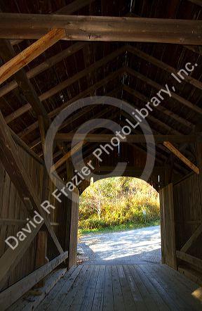 The Mill Covered Bridge crossing the Lamoille River in Belvidere, Vermont, USA.