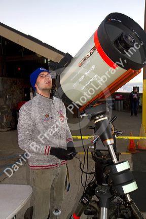 Man using a Celestron Telescope on top of the dormant volcano Mauna Kea located on the Big Island of Hawaii, Hawaii, USA.