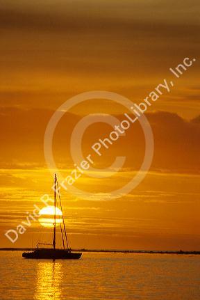 A sailboat at sunset in Tahiti.