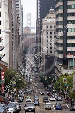 California Street scene with traffic in, San Francisco, California.  Tower of Bay Bridge in the mist.