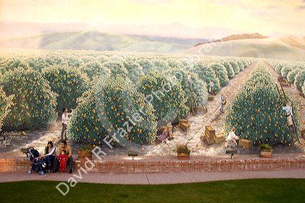 A family sits in front of a mural painted on the side of a building in Exeter, California.