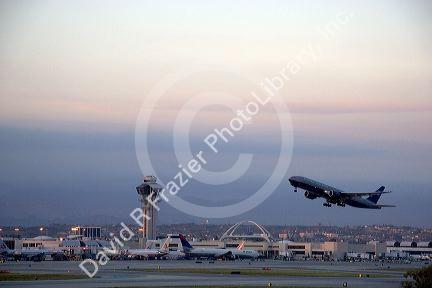 Boeing 767 airplane taking off at LAX airport, Los Angeles, California at dusk.