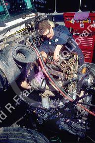 A male truck mechanic working on a diesel engine.