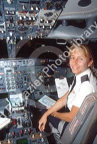 Female airline co-pilot reviewing checklist in cockpit of Boeing 737.