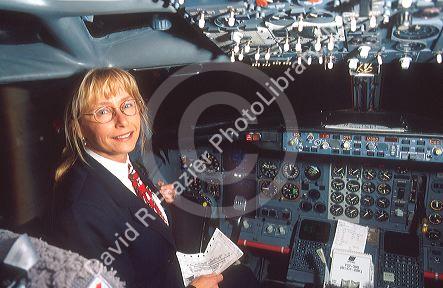 Female airline pilot reviewing checklist in cockpit of Boeing 737.