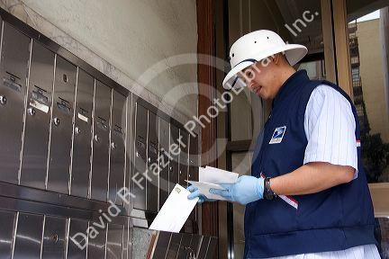 A  Chinese American mail carrier delivering mail in Chinatown, San Francisco, California.