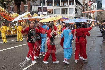 Girls holding umbrellas perform in the Chinese New Year Parade, Chinatown, San Francisco, California.