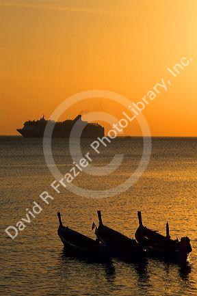 A cruise ship at sunset of the coast of Phuket Island, Thailand.
