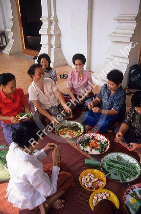 Thai women preparing alms for Buddhist monks at Chiang Mai.