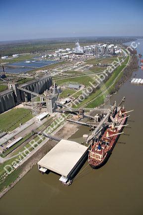 Grain elevators and river barge being loaded along the Mississippi River near New Orleans, Louisiana.