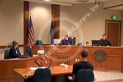 Court room scene with  in Boise, Idaho.  Criminal defendant   sits with back to camera.