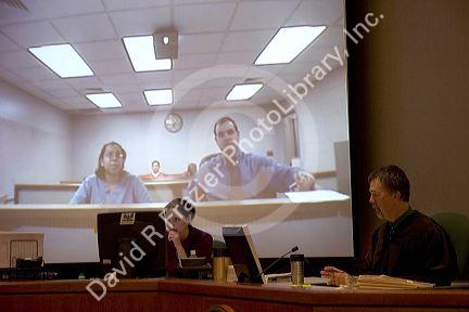 Video arraignment in criminal court in Boise, Idaho.  Defendants appear on video screen from secure jail facility while judge in courtroom conducts arraignment and sets bond.