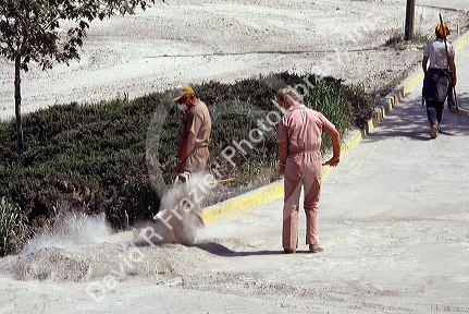 People wearing face masks clean up ash in the aftermath of the Mount St. Helens eruption 1980. Pullman, Washington.