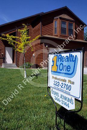 Real estate sign showing a home is for sale.