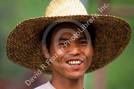 Portrait of a Filippino farmer wearing a straw hat.