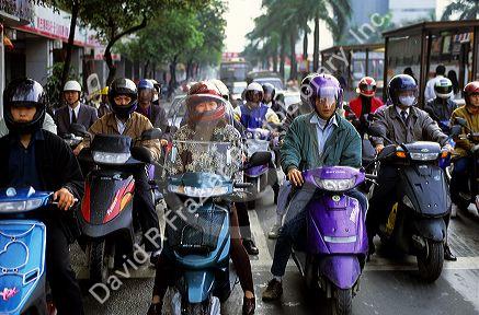 Commuters wear helmets while riding scooters in Taipei, Taiwan.