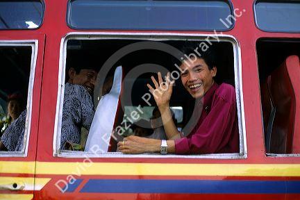 A bus passenger waving in Vietnam.