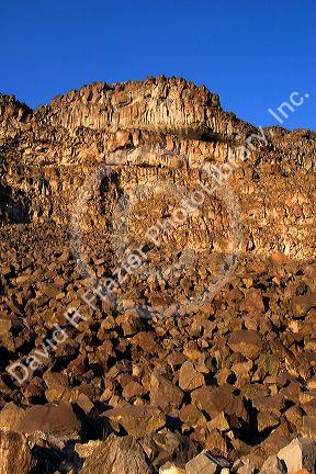 Boulder field of basalt rock which has eroded through freezing and thawing action. Cliff is on the Snake River Canyon in Idaho.