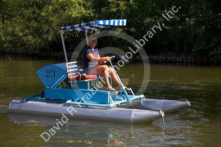 Fifteen year old girl uses a paddlewheel boat on the lagoon in Julia Davis Park, Boise, Idaho.