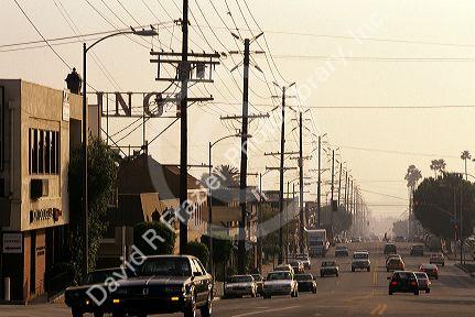 A Los Angeles street lined with cars and electric power lines, California.