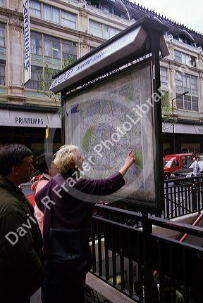 Tourists look at a city map in Paris, France.