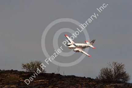 Twin engine aircraft used to guide fire retardant tankers during wildfire in Idaho.