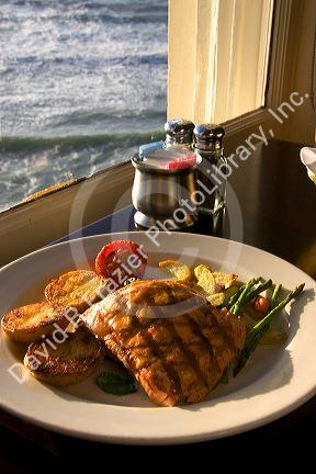A dinner of salmon and ocean view at The Cliff House Restaurant on the San Francisco Coast, California.