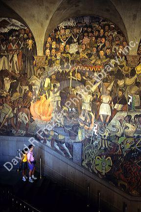 Visitors look at a Diego Rivera mural at the National Palace in Mexico City, Mexico.