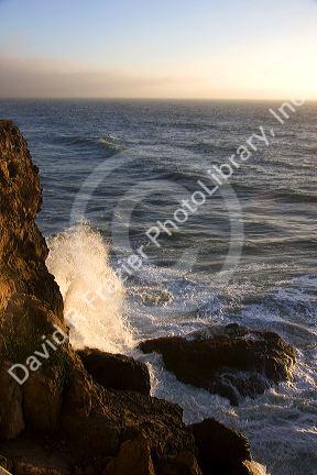 Ocean waves crash into rocks on the California Coast near San Francisco, California.