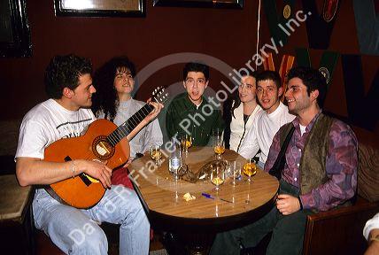 Spanish college students sing along to a guitar being played at a club in Barcelona, Spain.