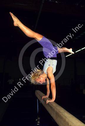 A female gymnast on a balance beam.